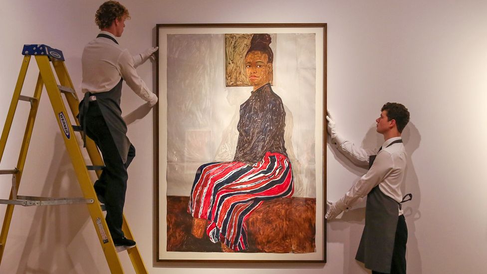 Art handlers hold Amoako Boafo's Joy Adenike portrait at Christie's auction house in central London, UK - 20 June 2023