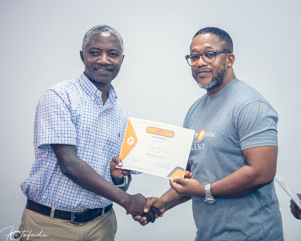 Dr David Okyere Head of Agency Banking presents certificate to Patrick Amankwah Arthur Fidelity Agent