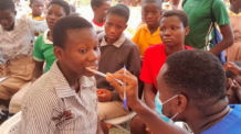 Dr. Newton – Inspecting the Vocal Cavity and Teeth of Students of Pokuase M. A. Basic School