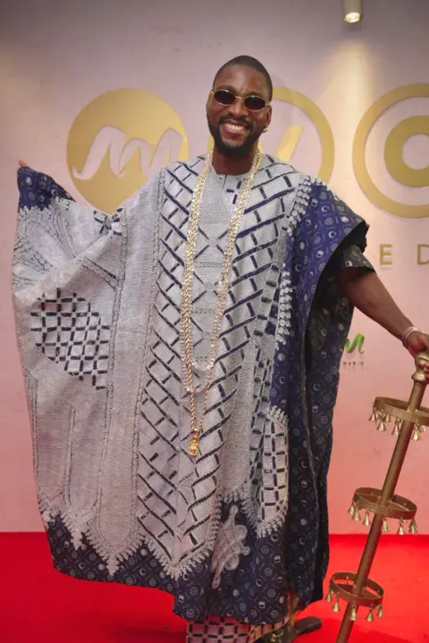 BBC/GIFT UFUOMA Tobi Bakre wears traditional costume and holds a brass cane