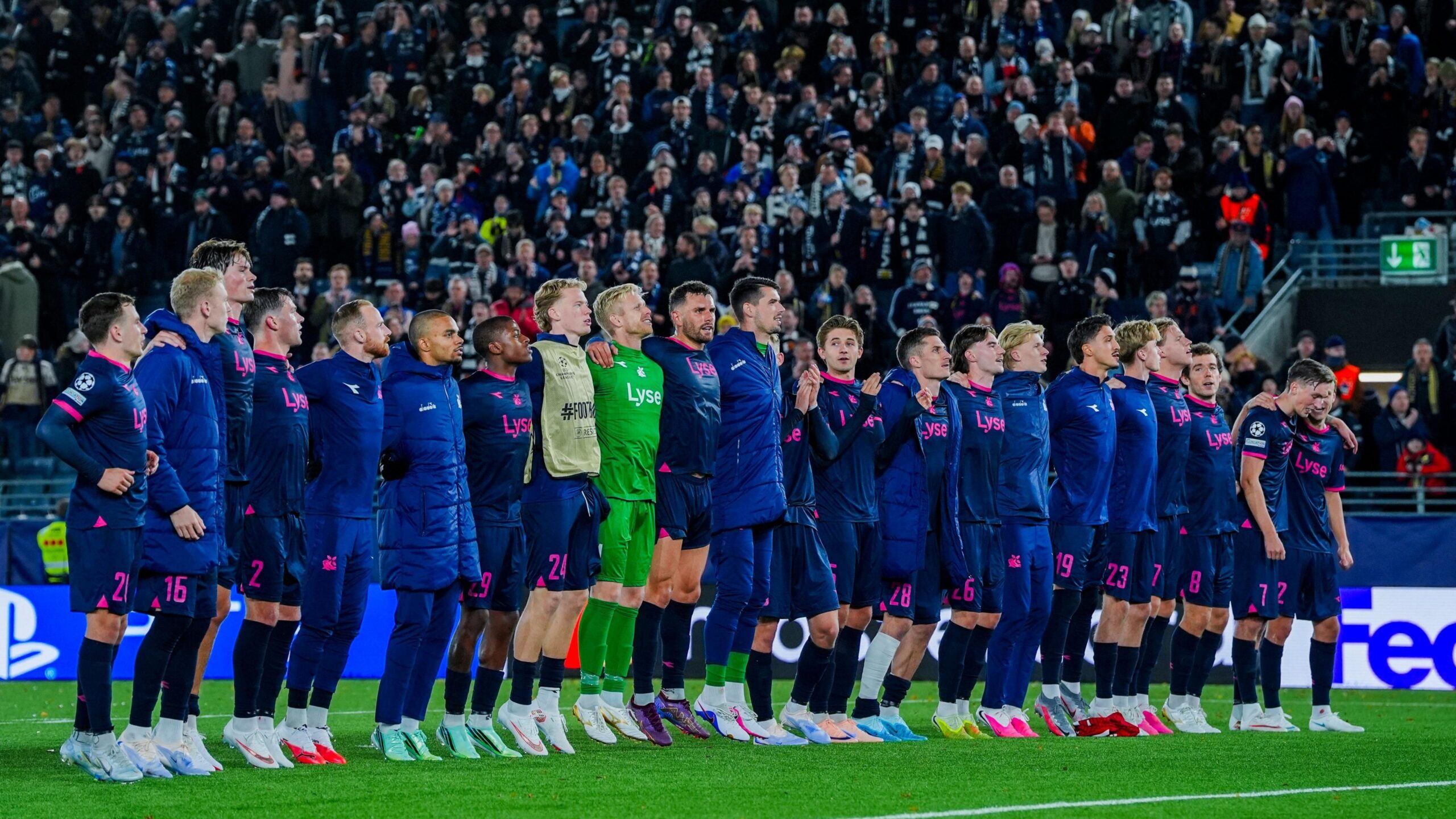 Viking players line up and link arms to celebrate with their fans after a 3-3 draw with Bayern Munich in the Champions League